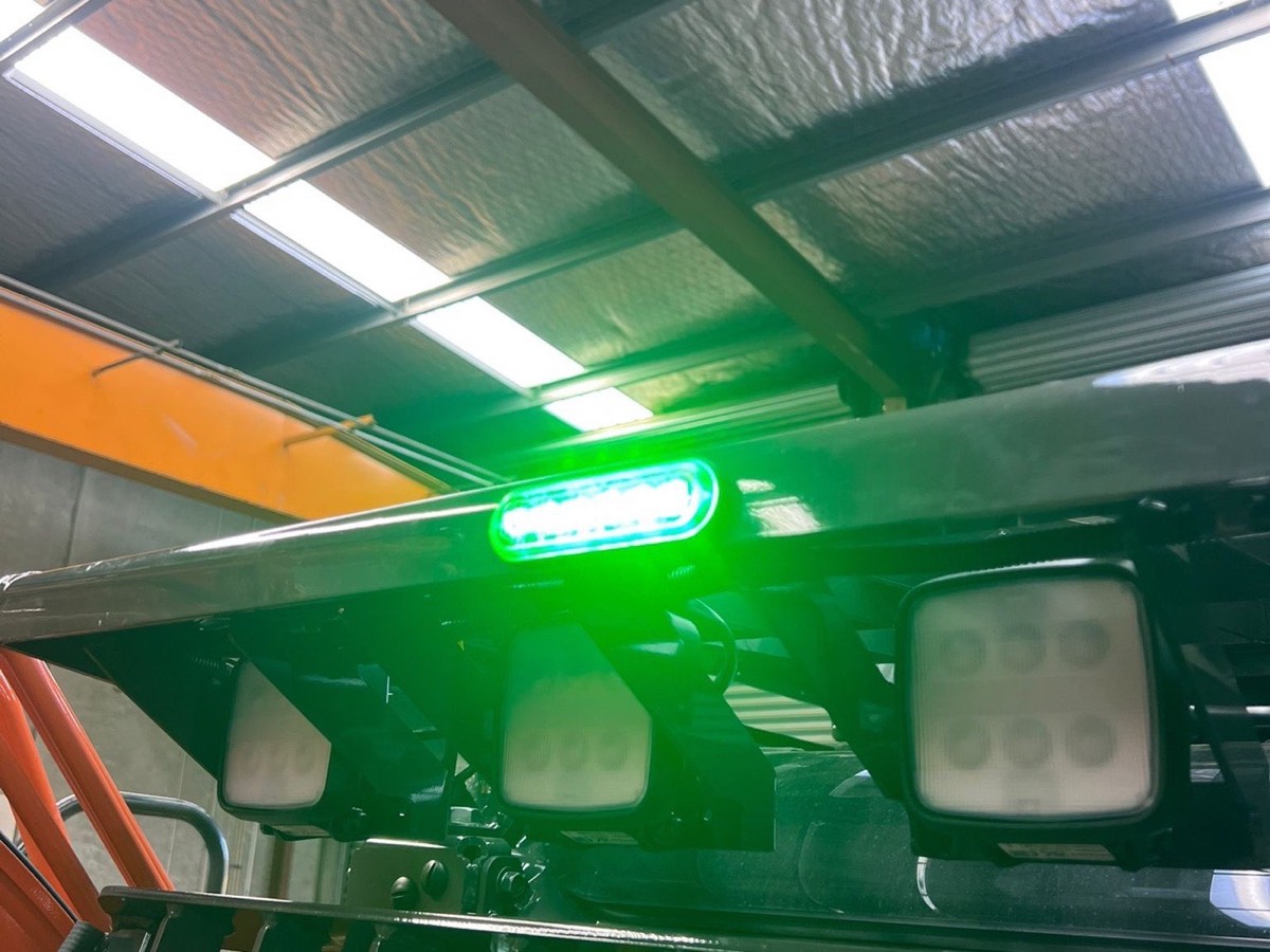 Green safety beacon and LED work lights fitted to a forklift overhead guard